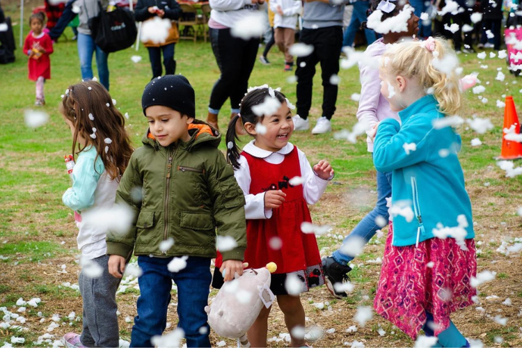 Five young children play as large snowflakes fall during a holiday party hosted by Door of Hope in Pasadena, CA.