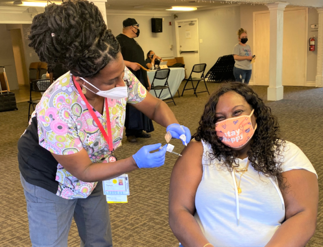 A woman receives a shot at a Harambee Ministries COVID-19 community vaccine clinic in Pasadena CA