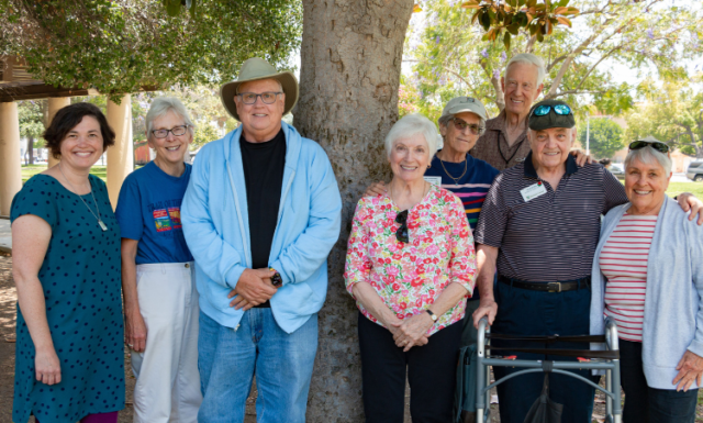 Members of Pasadena Village pose together under a tree.