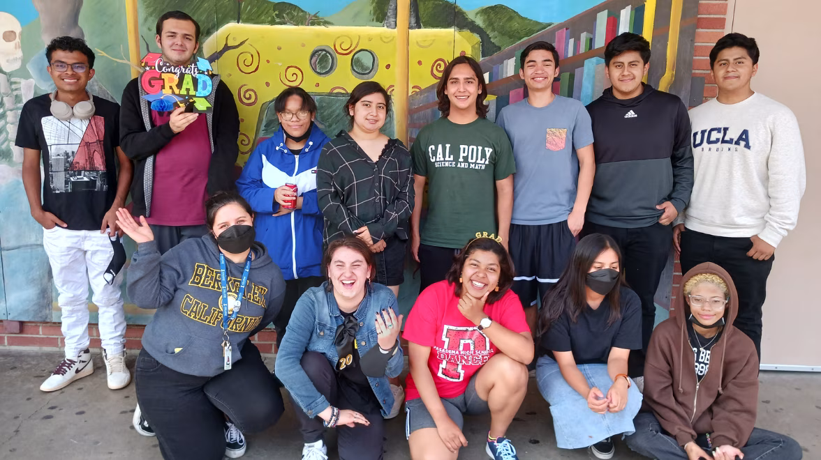 Several youth stand together, some kneeling in front, for a group photo