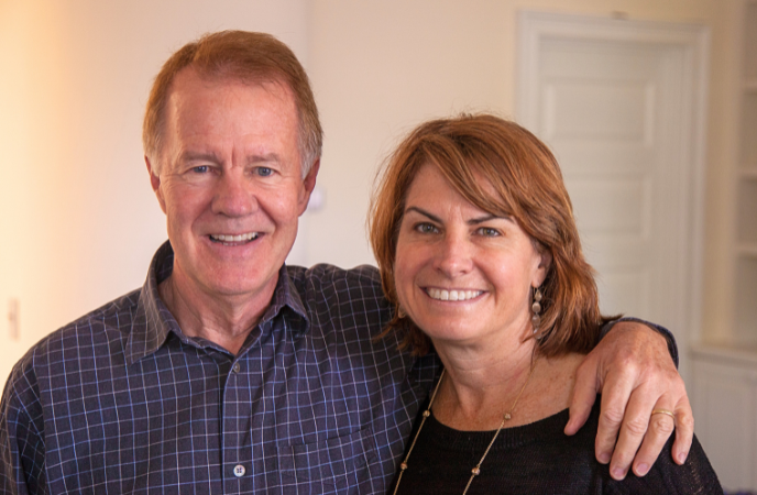 A middle age couple stand arm in arm