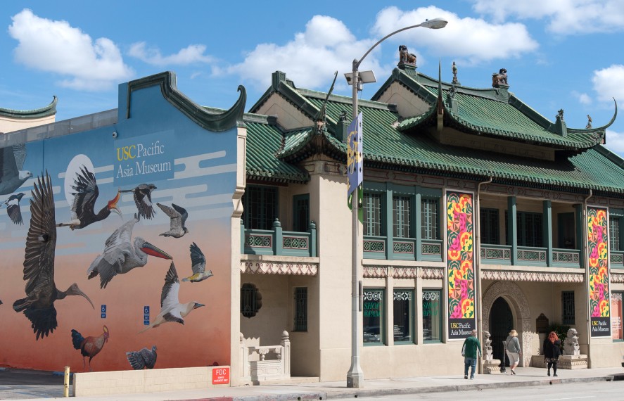 Asian archetectural building with mural of variety of sea birds on side of the building