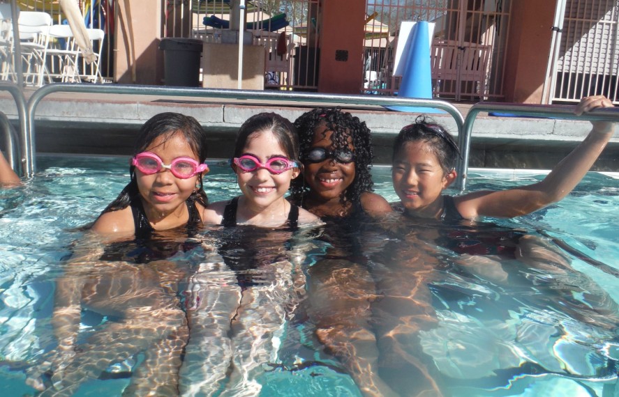 Four young girls posing for a photo in the pool