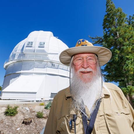 Man posing for photo in front of astonomy dome observatory