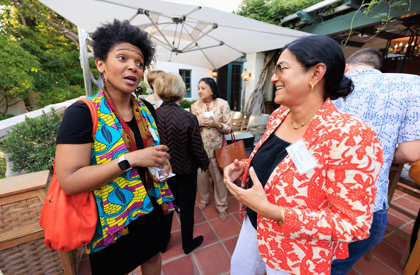 Two women talkng to one another outside at an event
