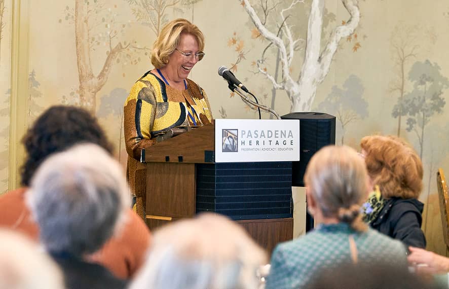 woman speaking at an event stading at a podium