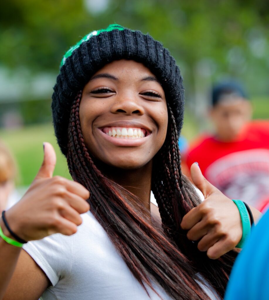 Young girl smiling with thumbs up