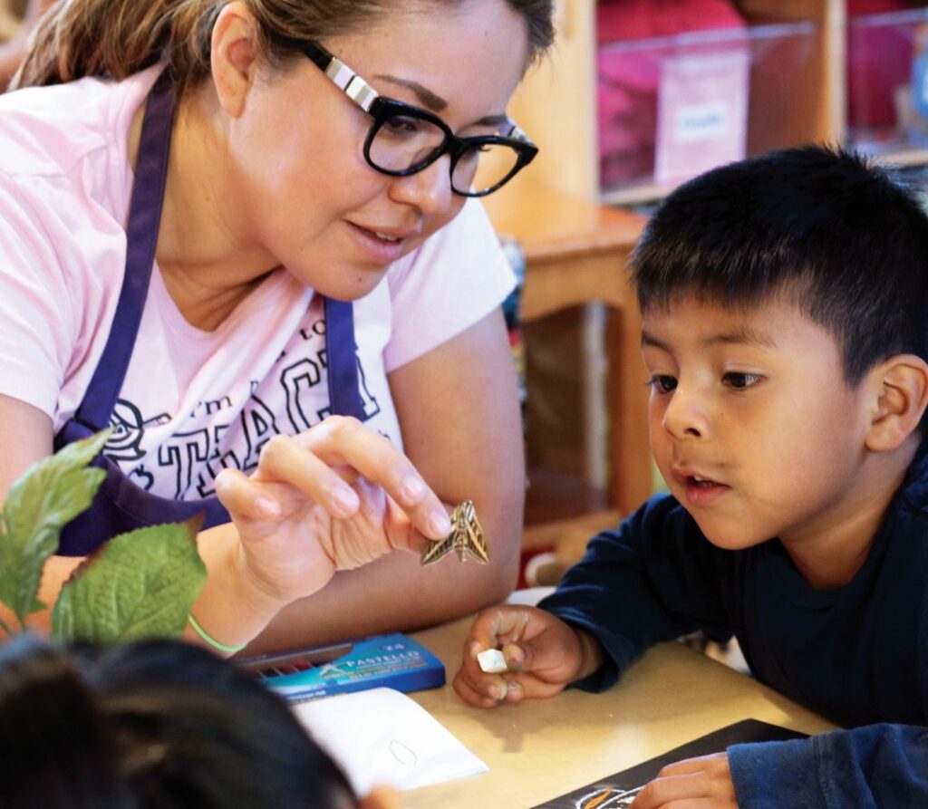 woman showing a kid an insect