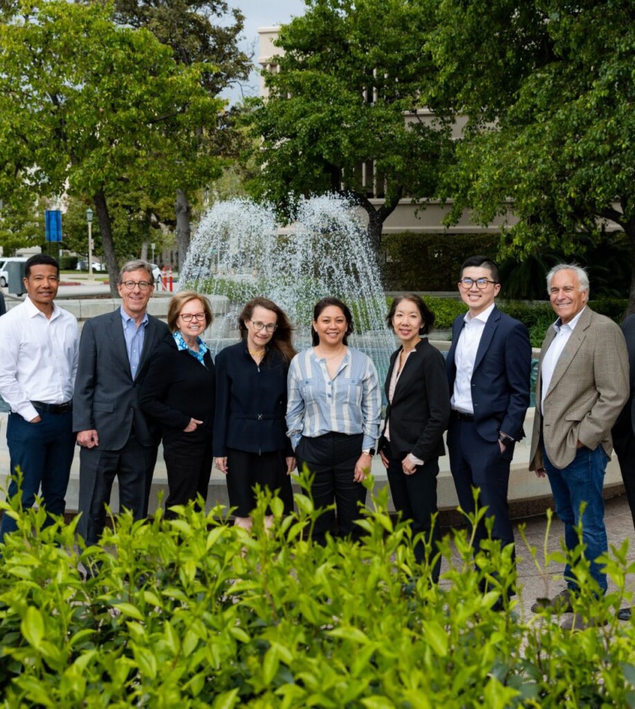 Team corporate group posing for a photo in front of a fountain
