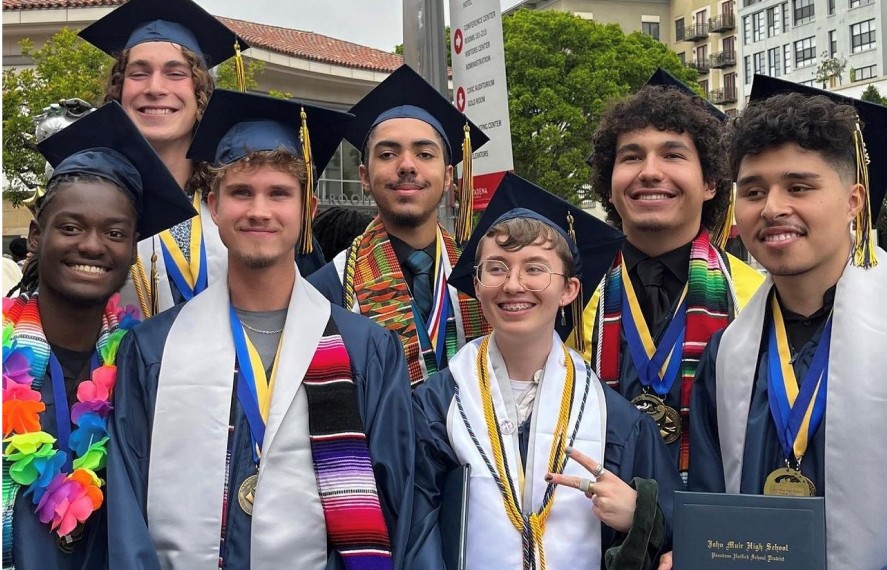 Group of graduates taking a photo smiling
