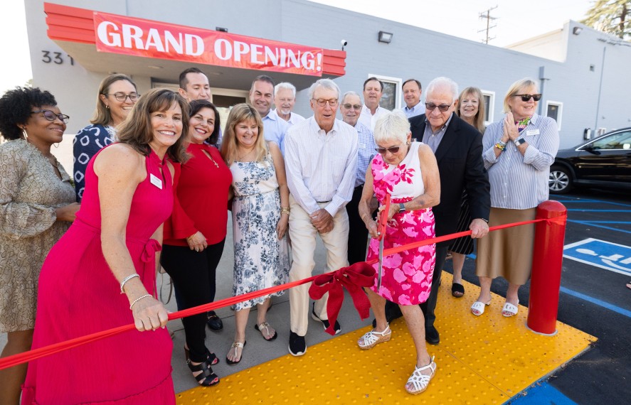 Group posing for a photo before cutting the ribbon