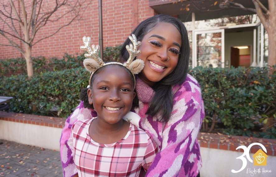 Mother hugging daugther with reindeer antlers