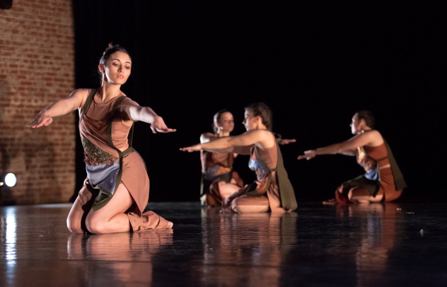 Dancers performing on stage in monotone costumes