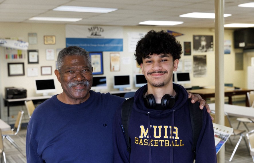 Father and son posing for photo in a school classroom