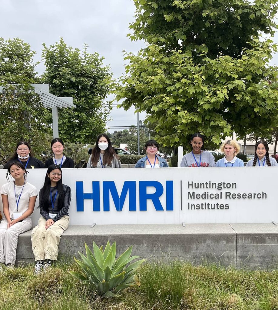 Group of students taking a photo in front of the HMRI sign