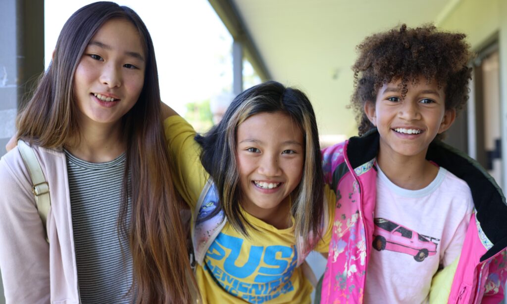 Three kids smiling for a photo