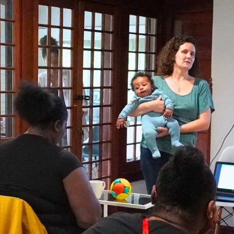 Woman holding a baby and walking