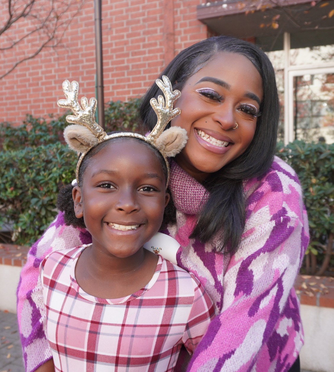 Mother hugging daugther with reindeer antlers
