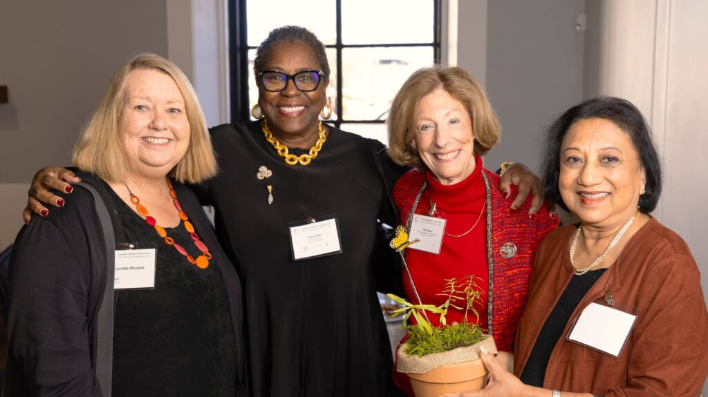 Four PCF women company members smiling for a photo
