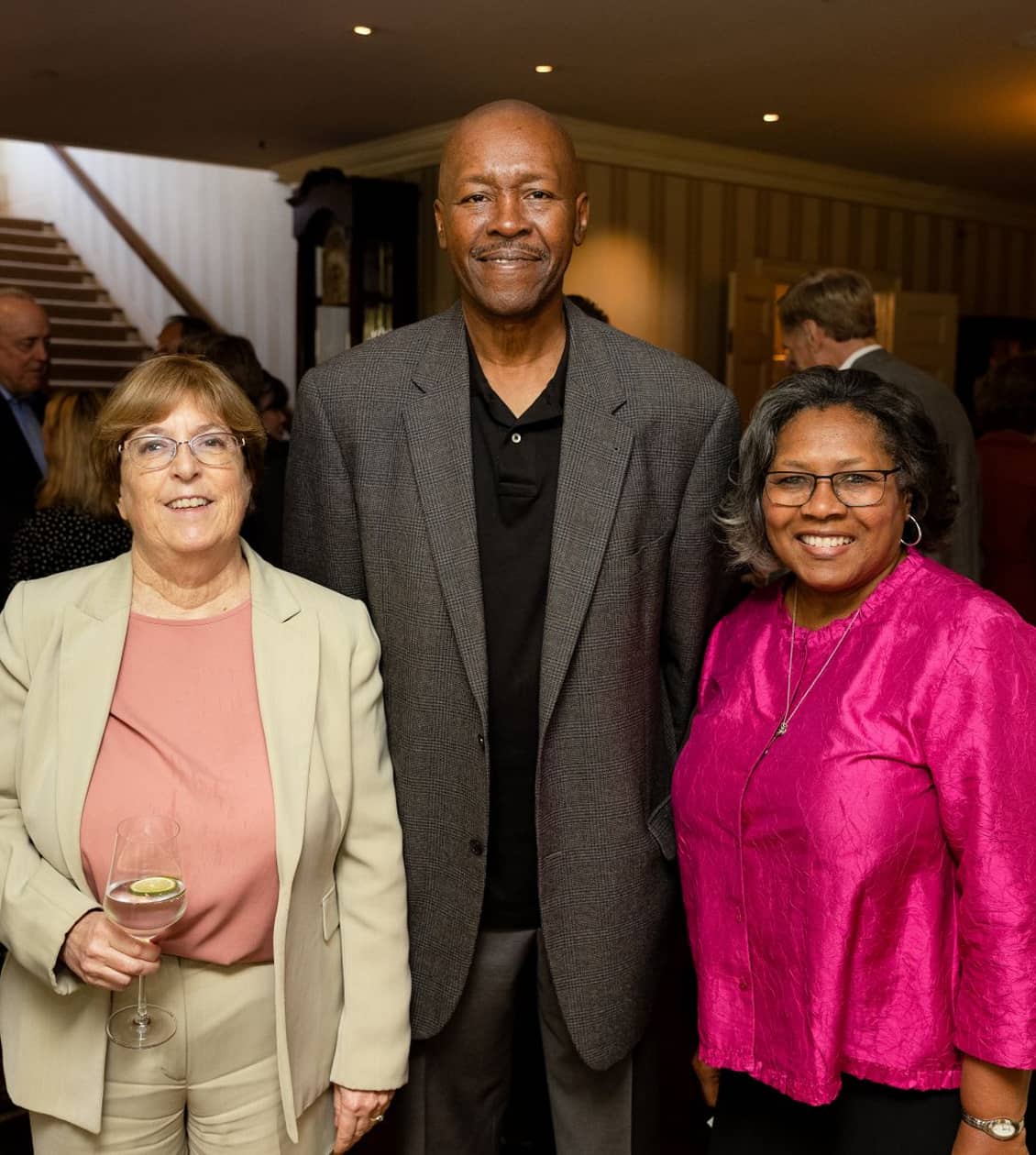 Two women smiling next to a very tall man, all smiling