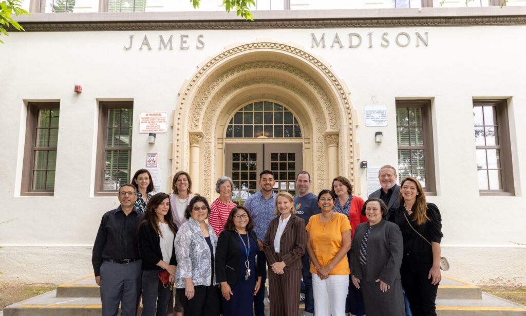 Team or group members posing for a photo infront of the James Madison building