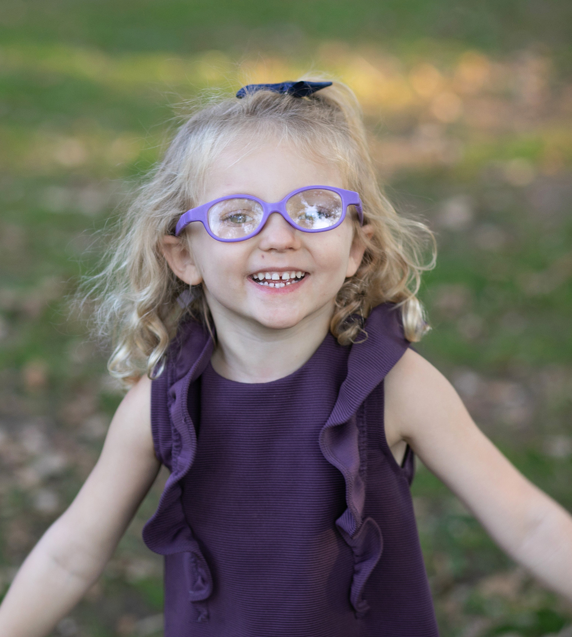 Little girl with purple glasses smiling