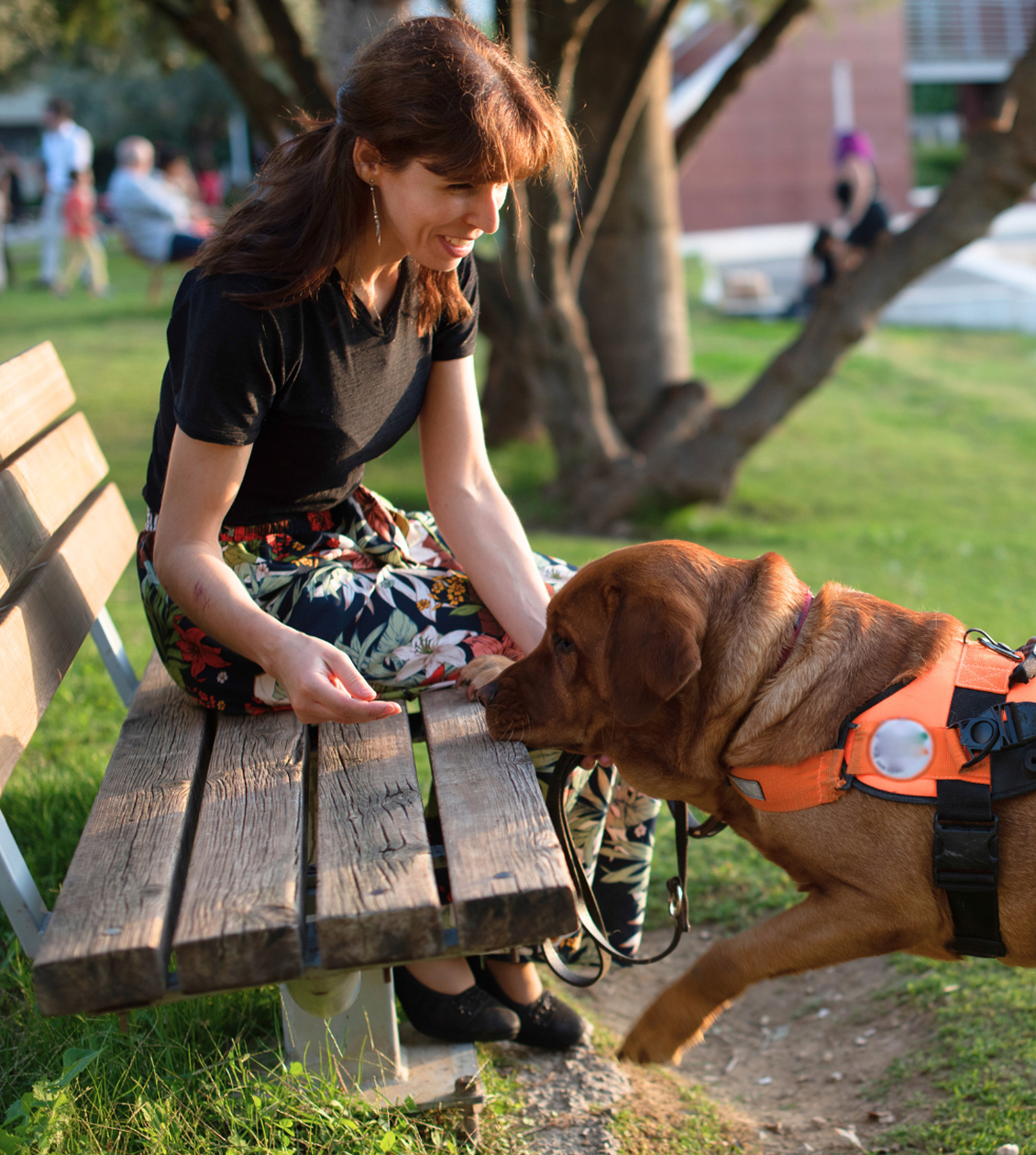 Women sitting on a bench with her guide dog