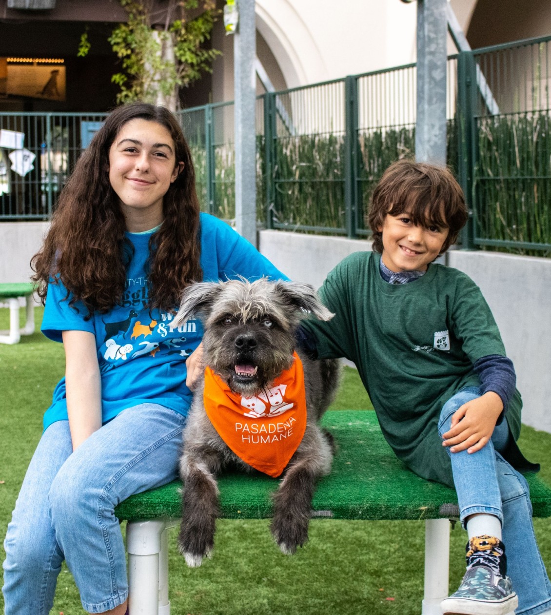 Two kids sitting with a dog