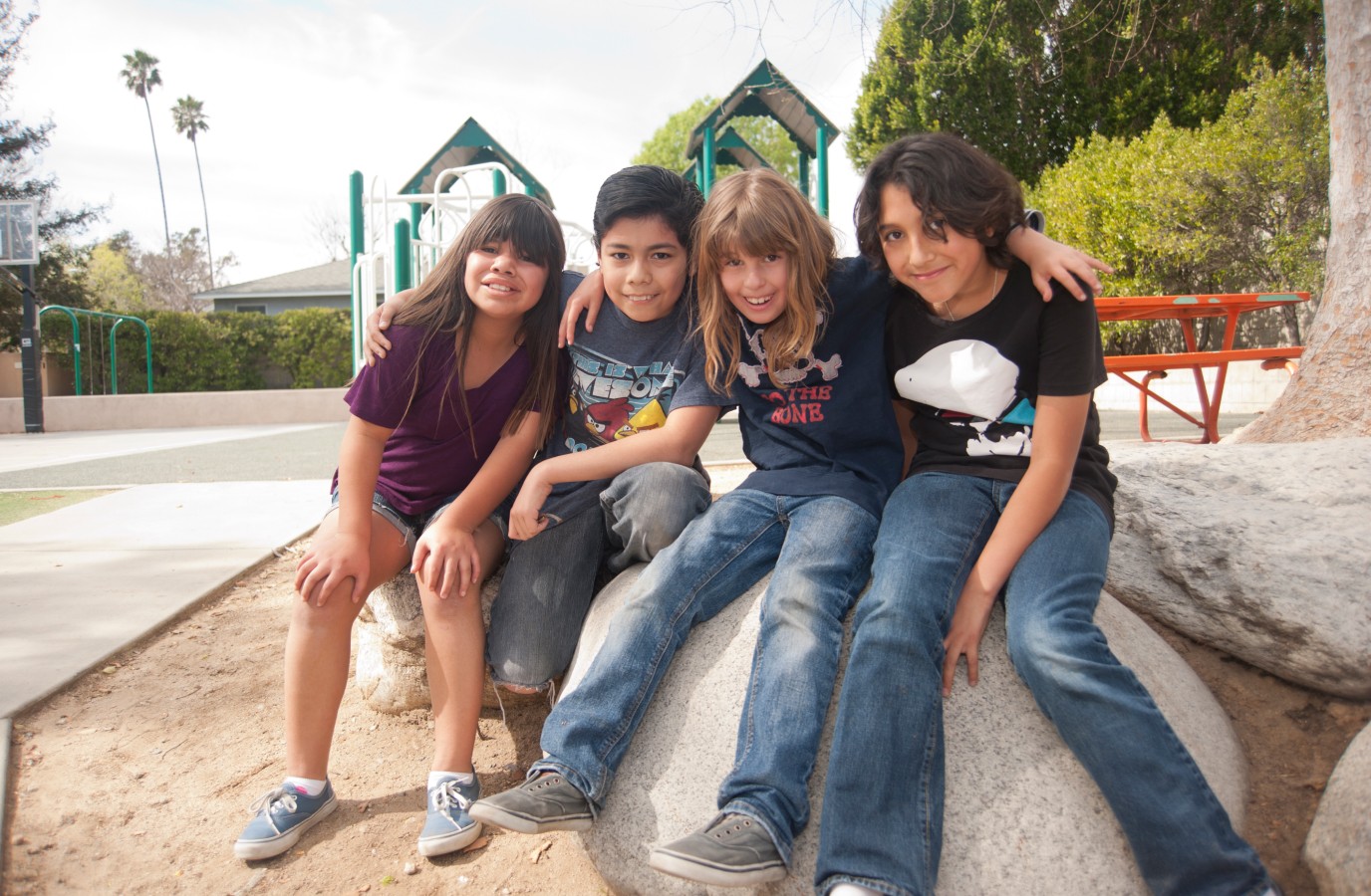 Group of kids sitting on a boulder