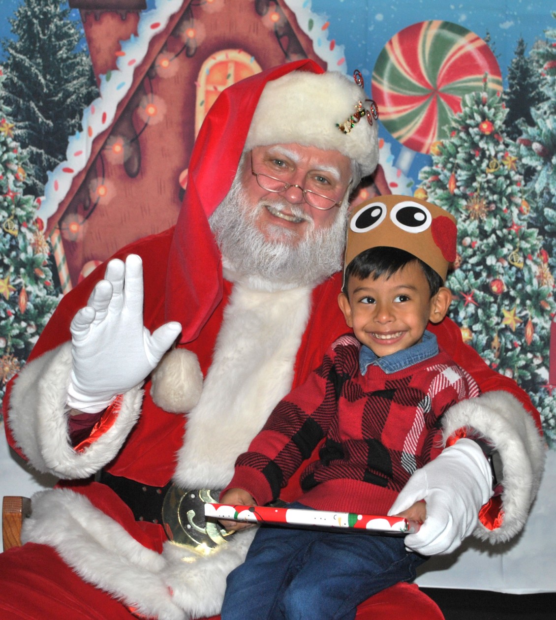 Little boy smiling while sitting on Santa's lap