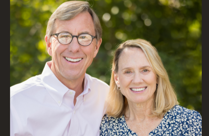A middle-age white couple stand together outdoors