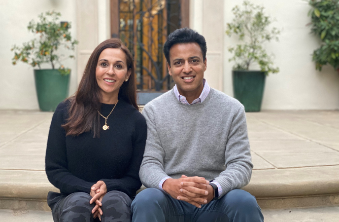 A couple of Indian descent sits together on the steps of a porch