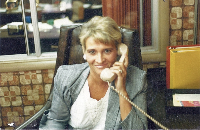 A vintage color photo shows a woman on a cord tele