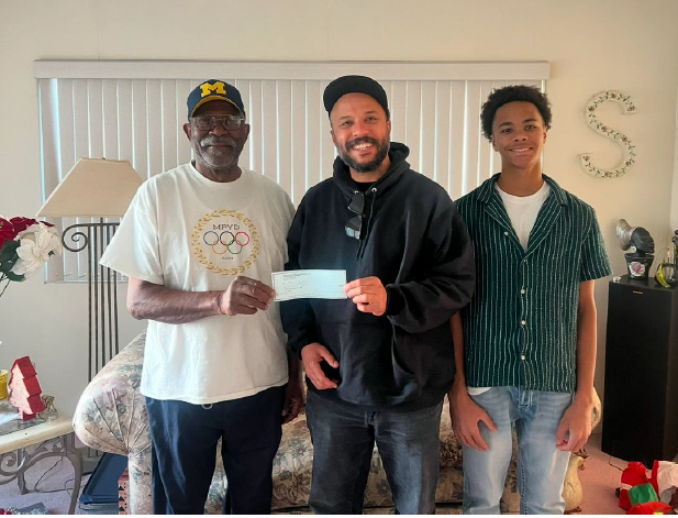 Three men holding a check