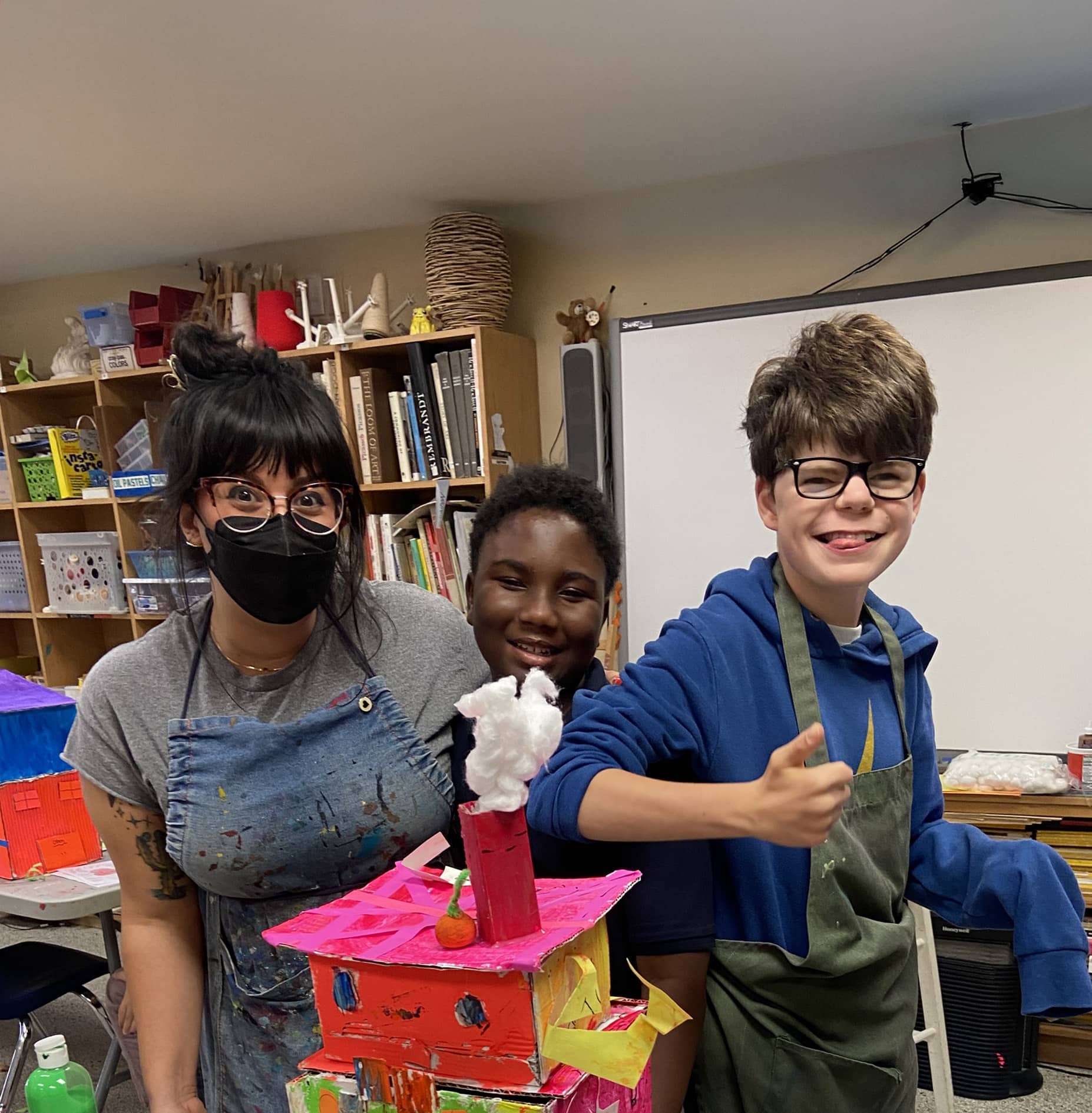 Teacher and kids smiling with their art structural building