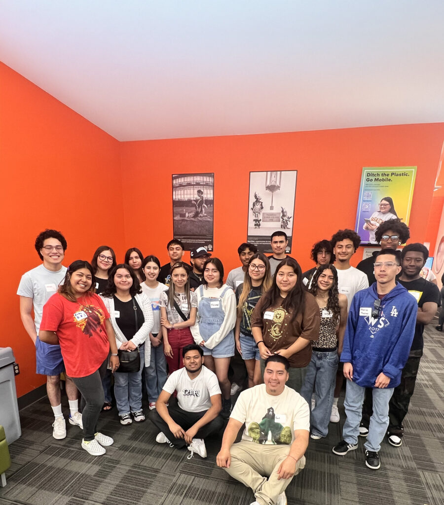 Group of students in an orange room taking a photo