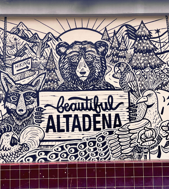 A mural showing numerous animals before a sunrise says Beautiful Altadena