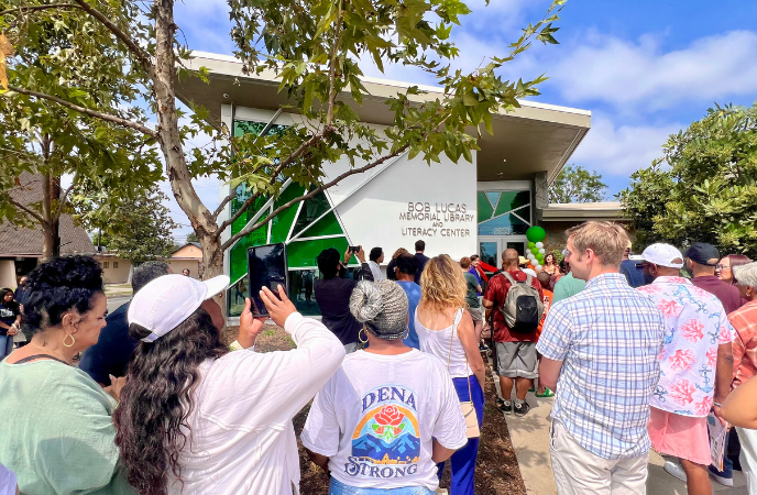 A large crowd stands outside the Bob Lucas Memorial Library and Literacy Center
