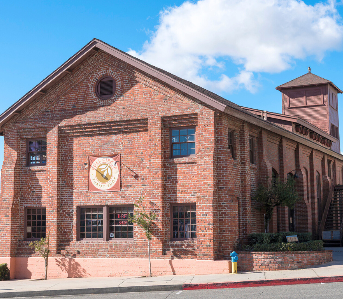 A historic red brick building with a circle sign that reads Full Circle Thrift