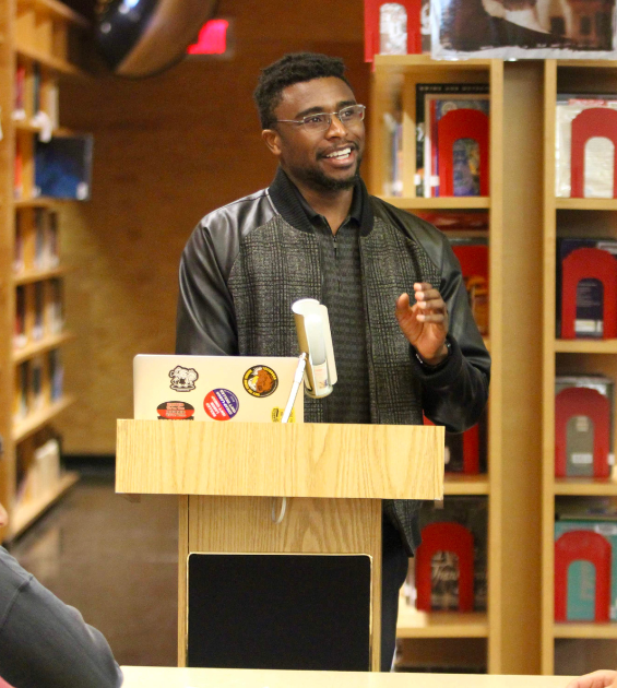 A young African American man presents at a podium