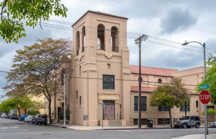 A historic brick church sits on a city street corner