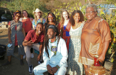 A group of African American adults gather together outdoors
