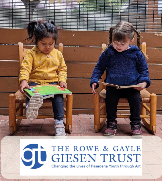 Two little girls sit on chairs outside reading books