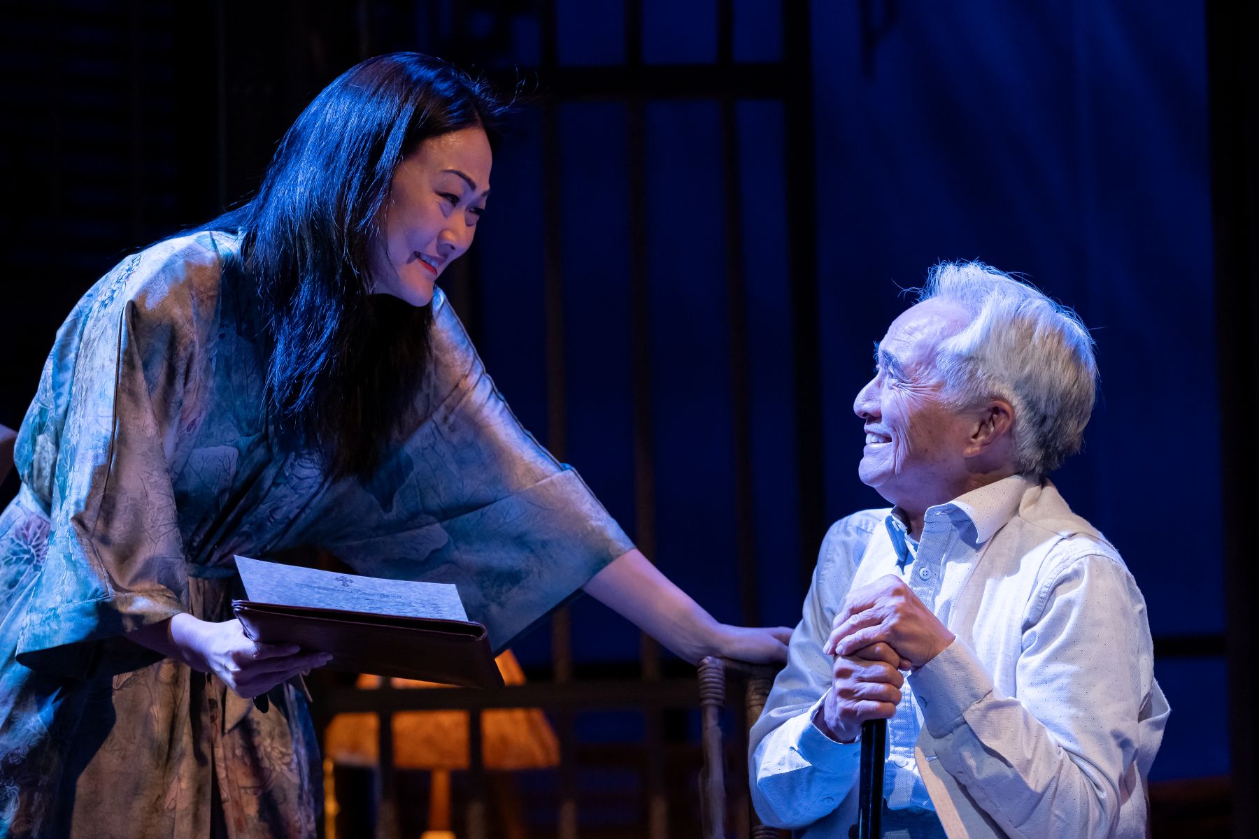 Two actors on stage in purple light
